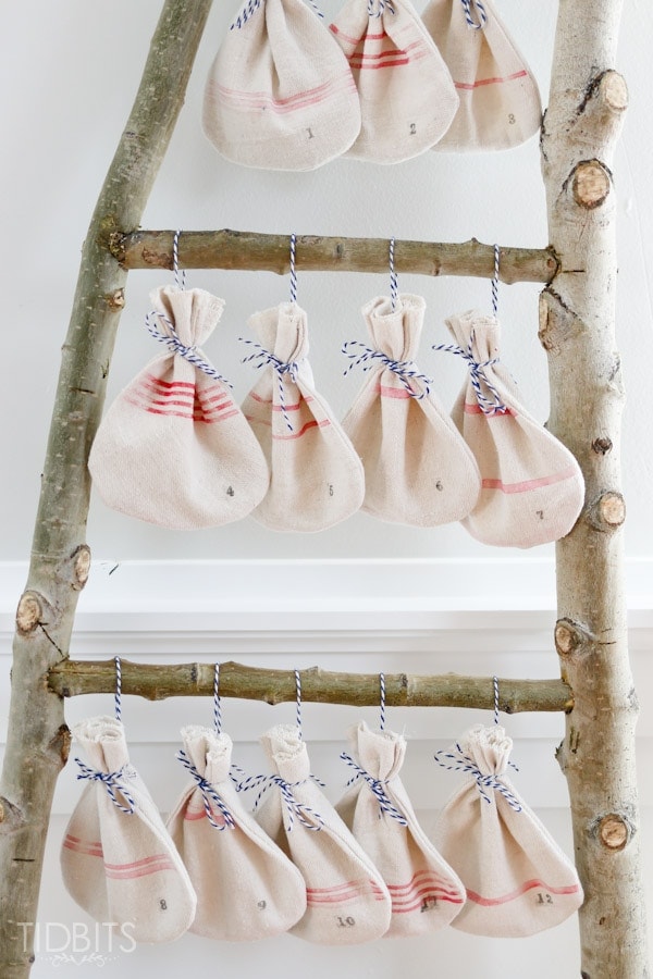 Christmas Countdown grain sack bags hanging on a log ladder. Pattern and tutorial available - by TIDBITS.