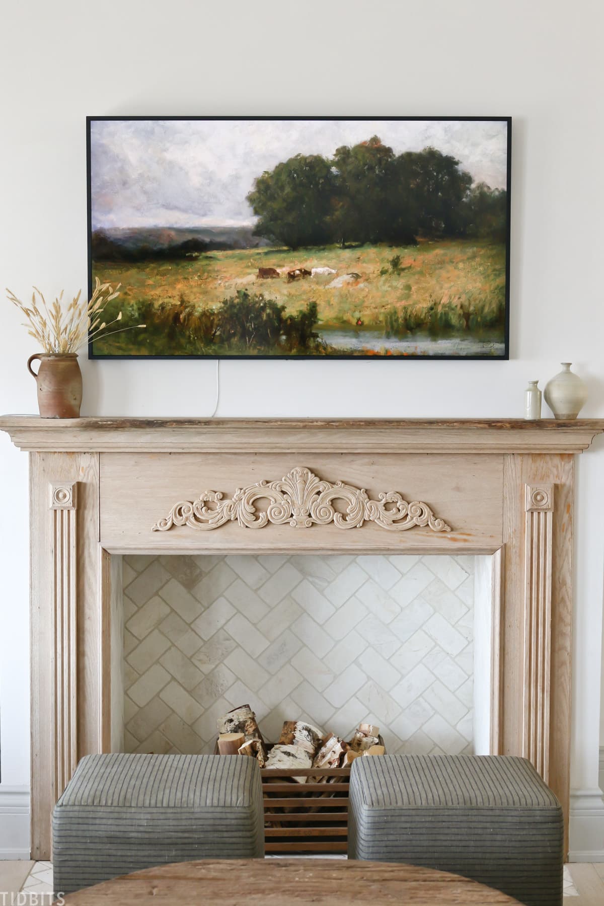 faux fireplace mantel with wood placed inside fireplace and vintage painting above mantel