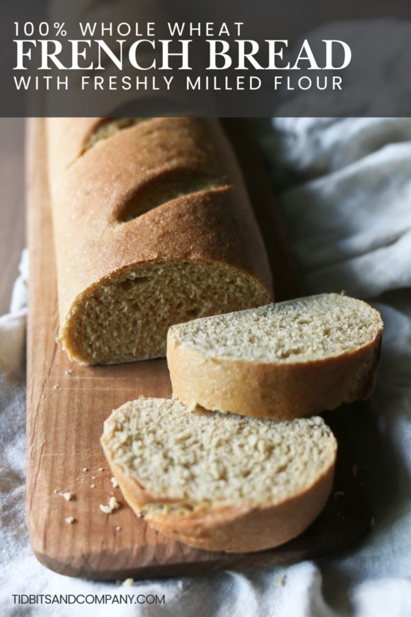 A sliced loaf of French bread rests on a wooden cutting board