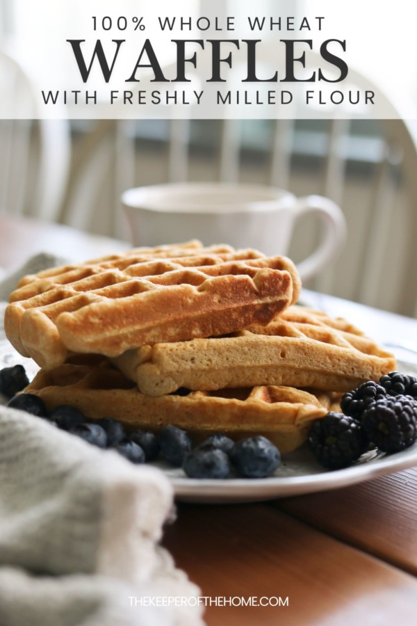 A stack of fresh milled flour waffles is stacked on a plate with blueberries and blackberries