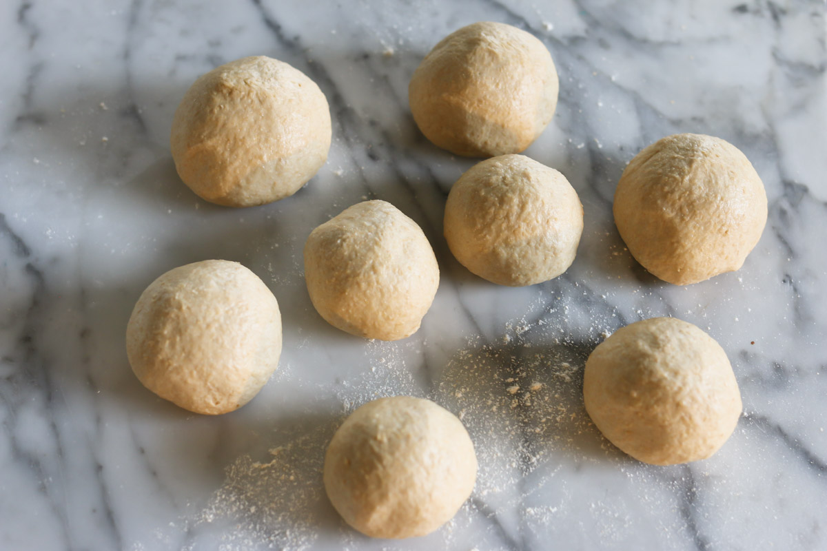 Balls of dough are formed on a countertop