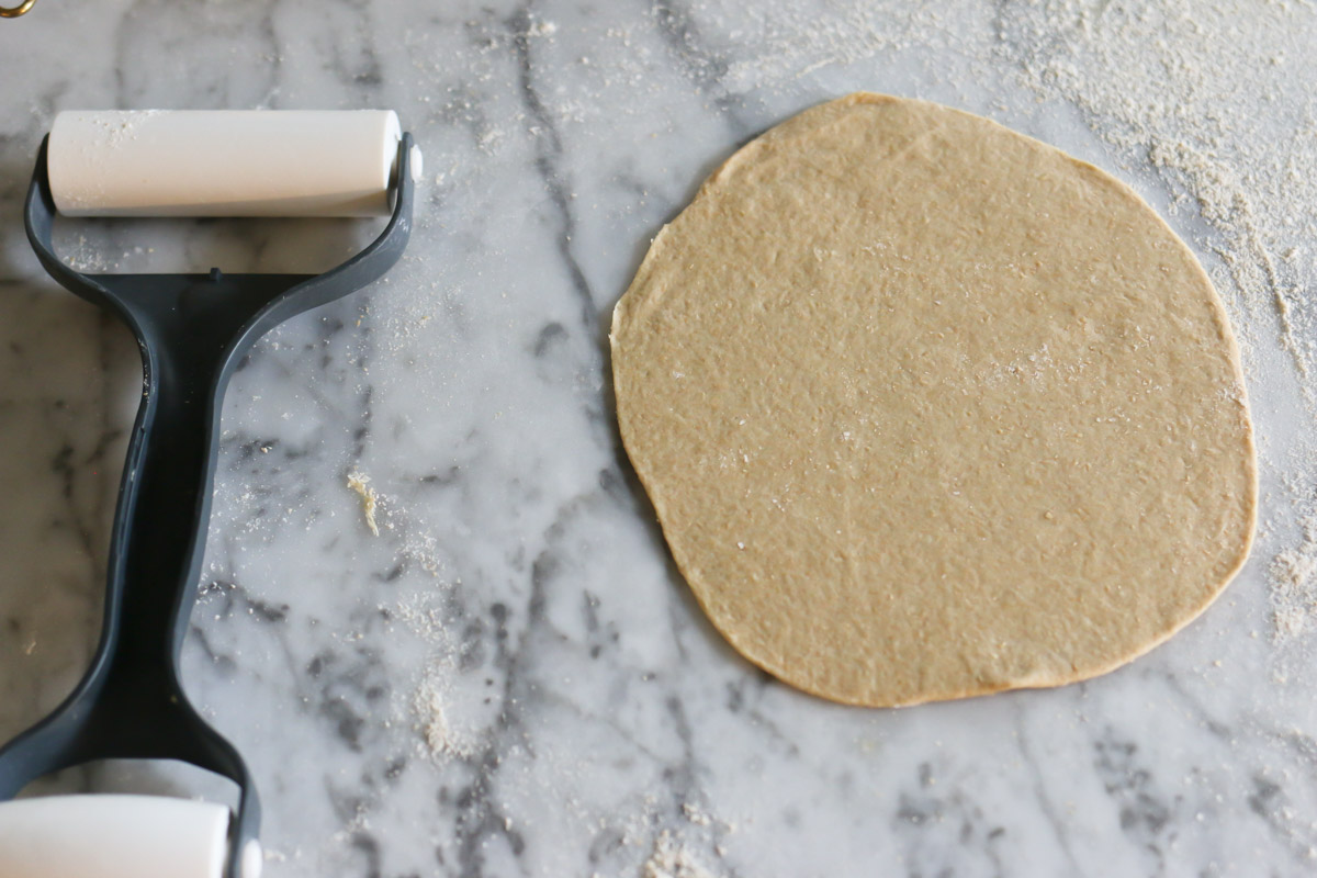Dough has been rolled into a thin, round circle to make an uncooked tortilla