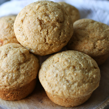 A plate holds several homemade muffins made from freshly milled flour