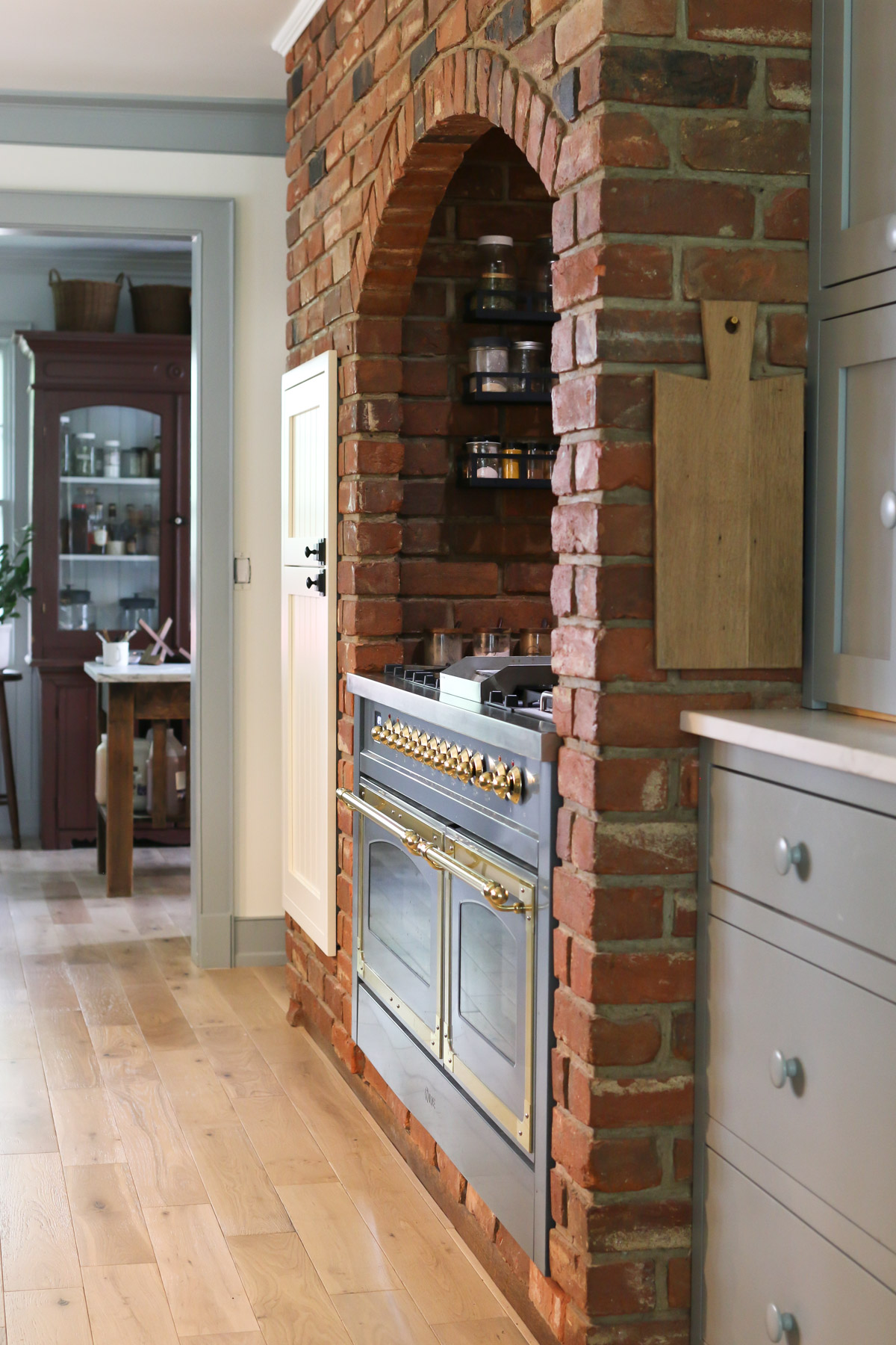 View down a kitchen with a red brick surround and an old fashioned ILVE range