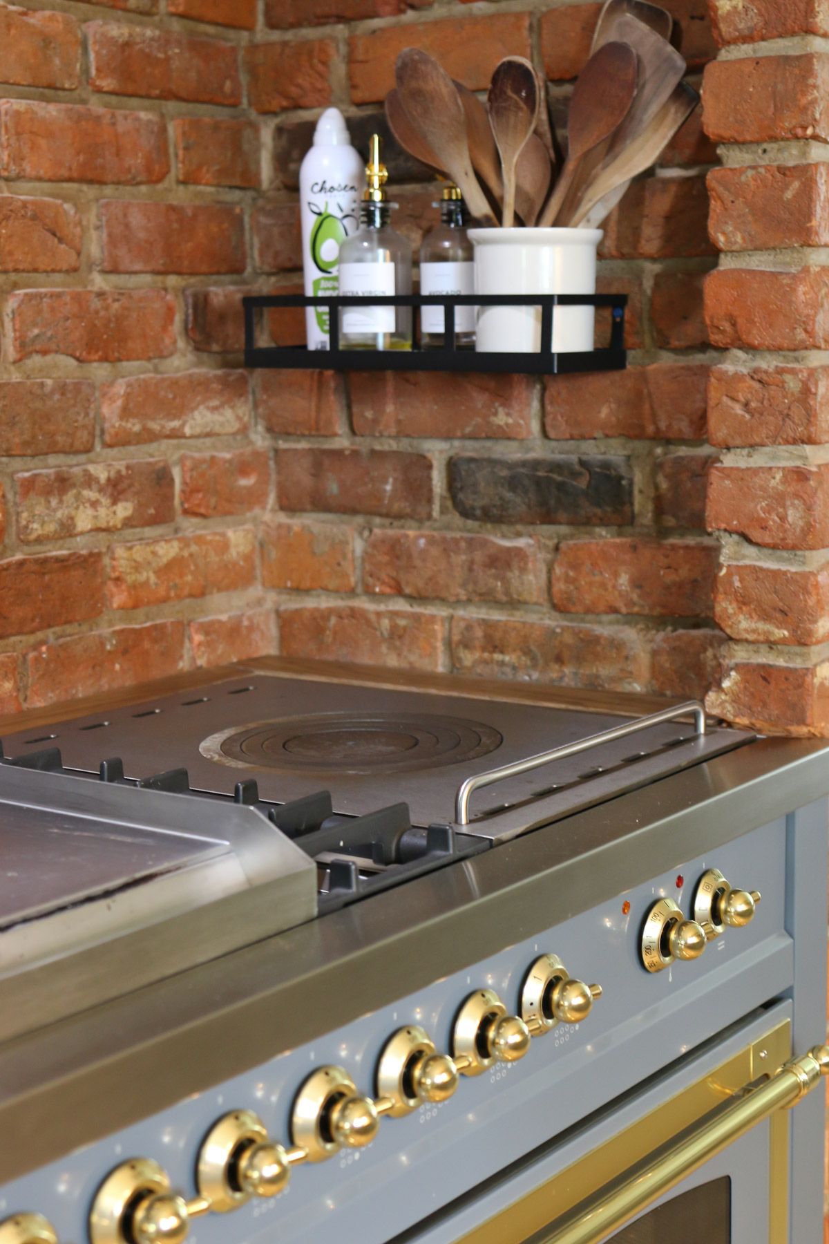 A french top, used for cooking and heating dishes, lies on the edge of a high-end ILVE range