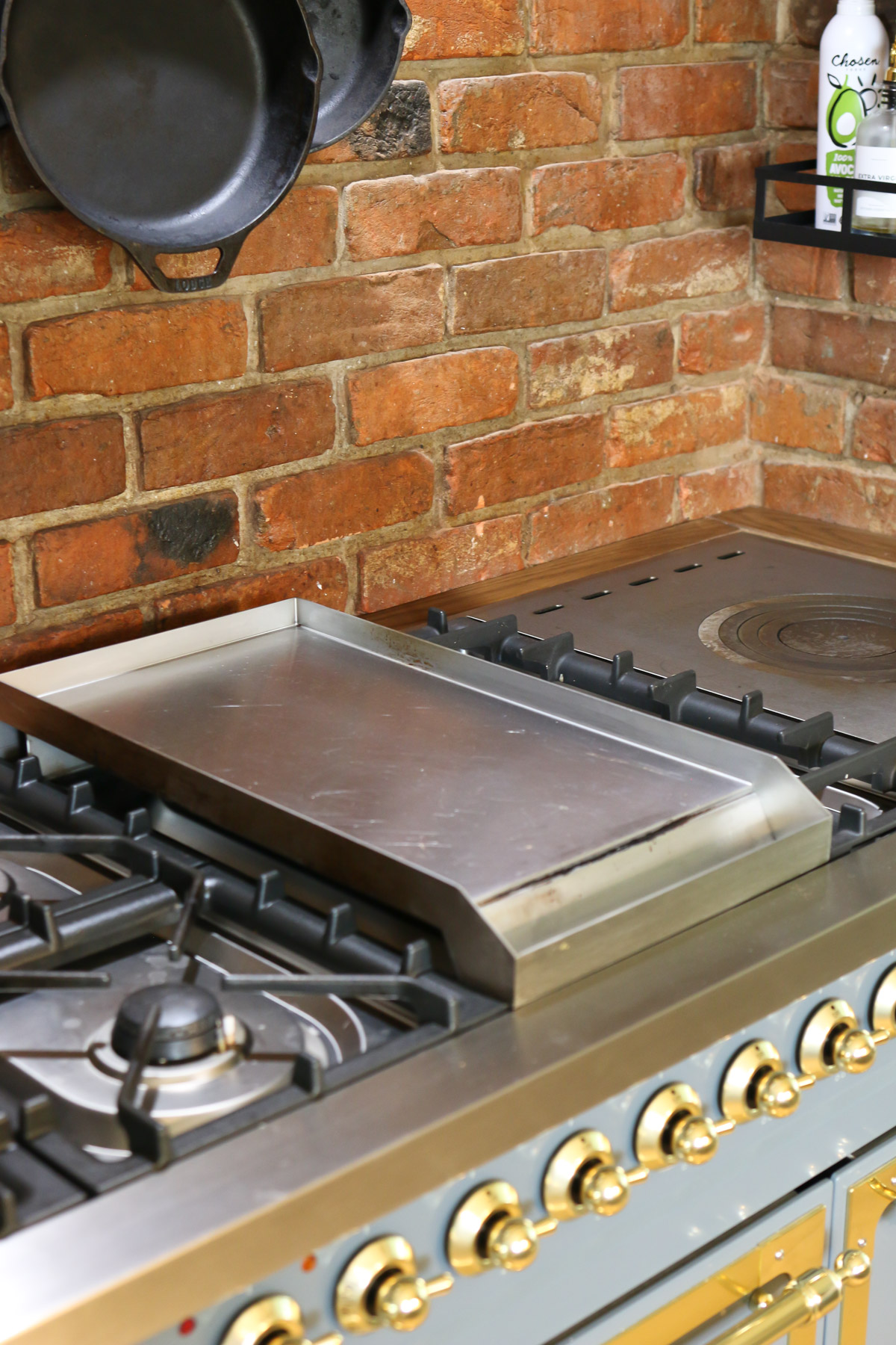 A large kitchen range features burners, a removable griddle. and a french cook top