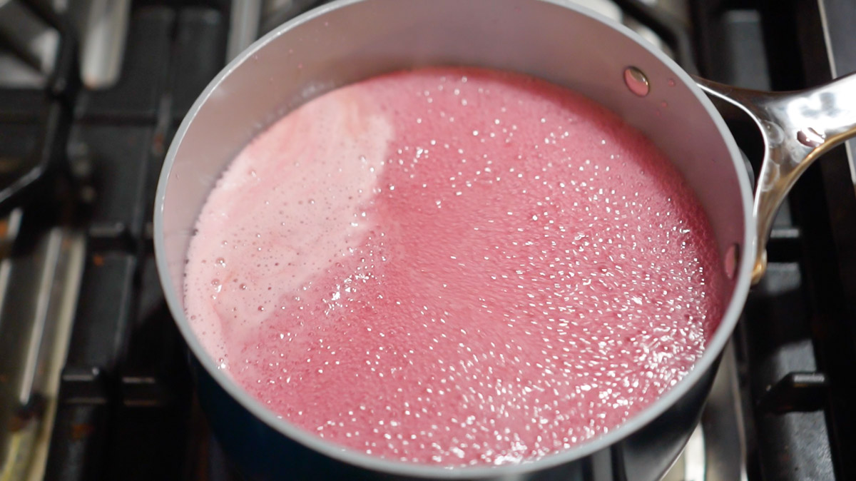 After adding sugar, lilac jelly is brough back up to a boil