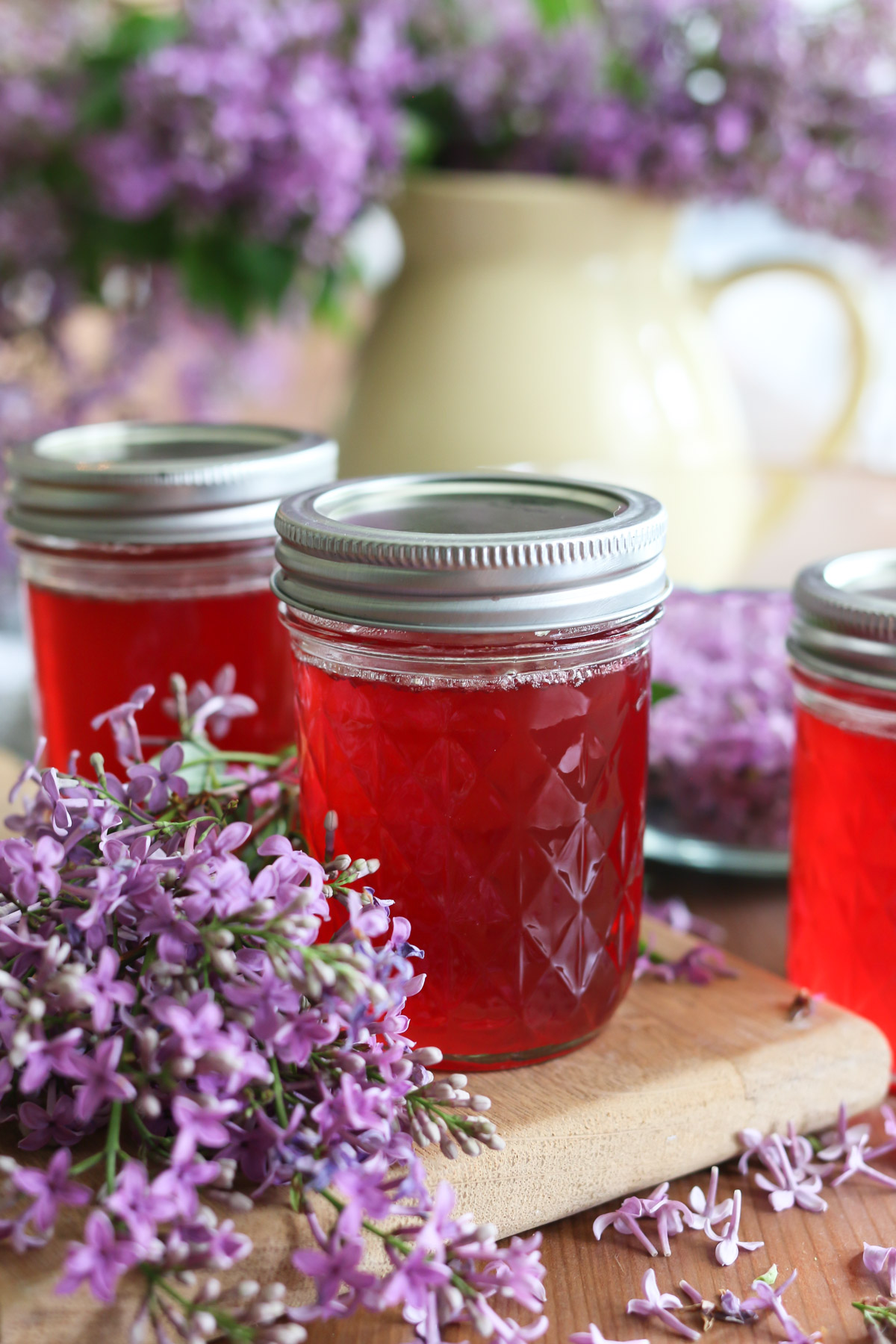 Jars hold pink jelly made from a lilac jelly recipe