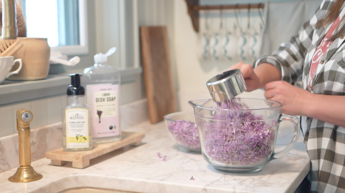 4 cups of lilac blossoms are measured into a glass bowl