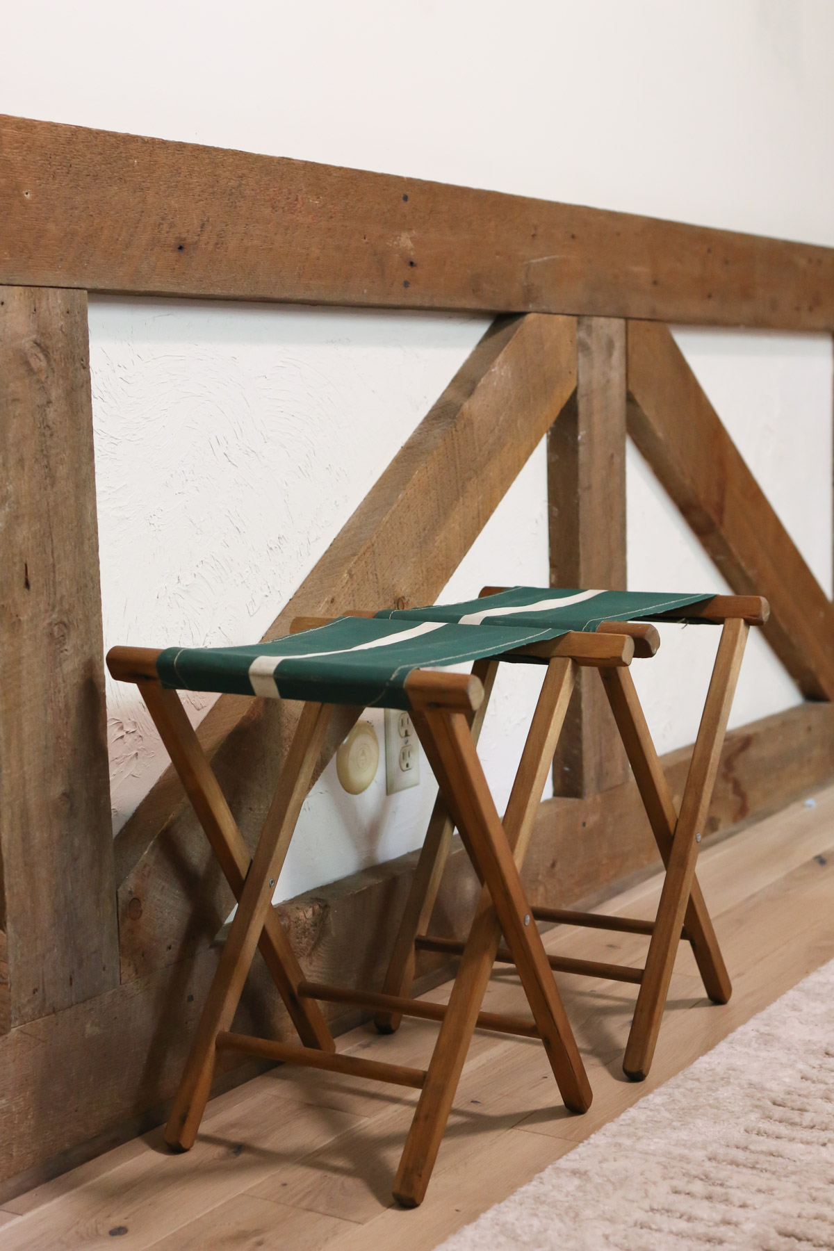 A wooden folding bench is used as vintage bedroom decor