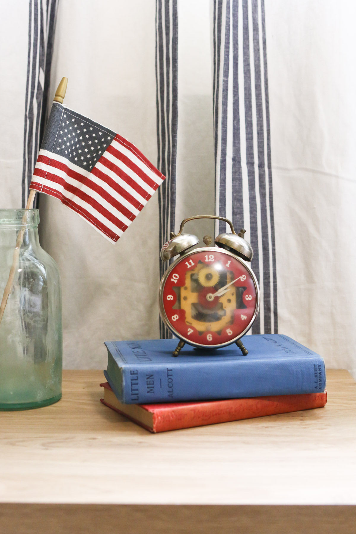 Close up of a small American flag and a vintage Americana alarm clock