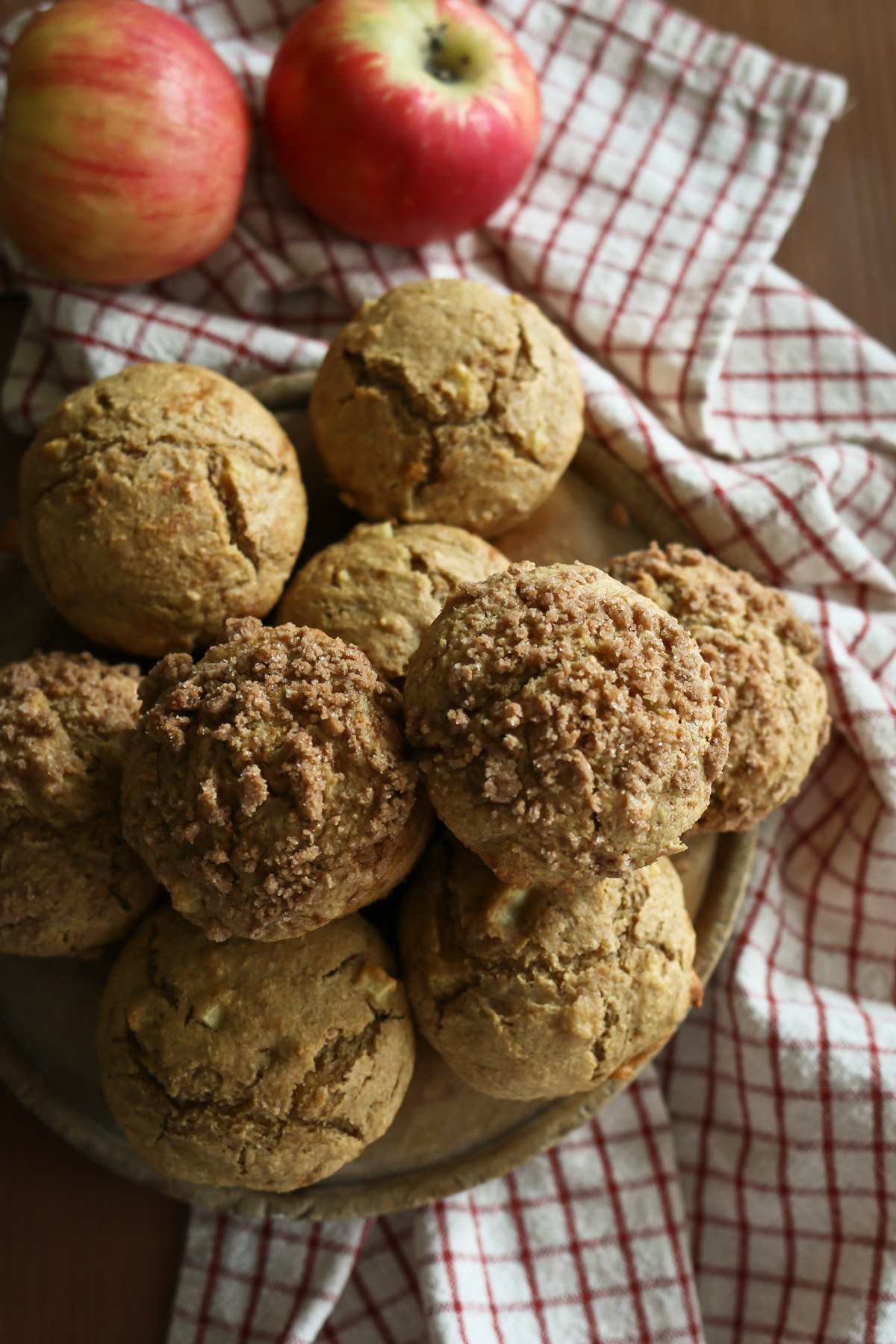 A serving plate filled with apple cinnamon muffins, some featuring a streusel topping