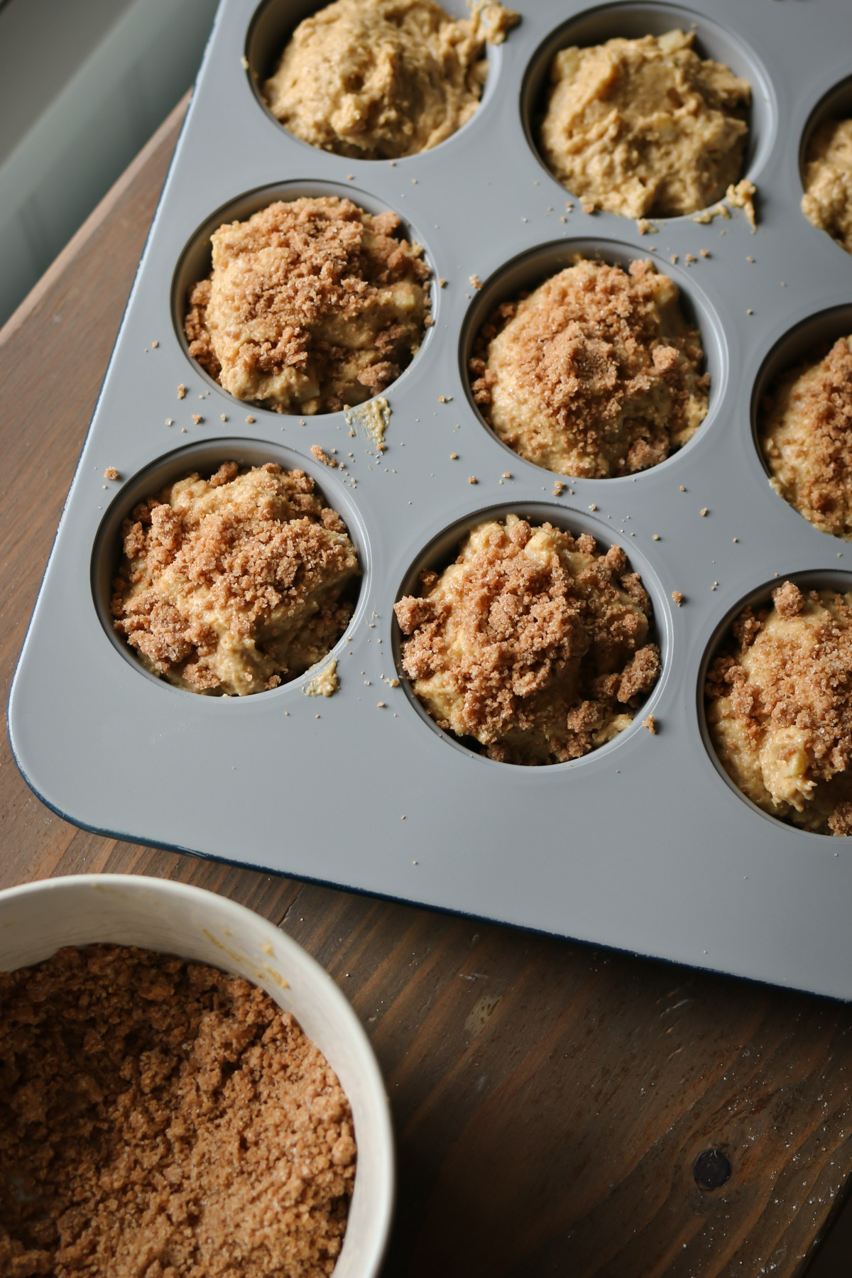 A muffin tin holds muffins made with apple, cinnamon and freshly milled flour