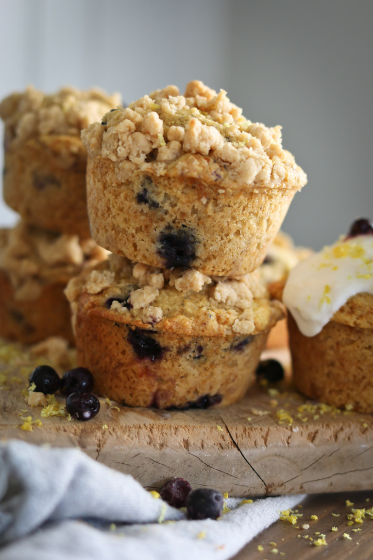 Several muffins made with lemon and blueberries are arranged in a stack