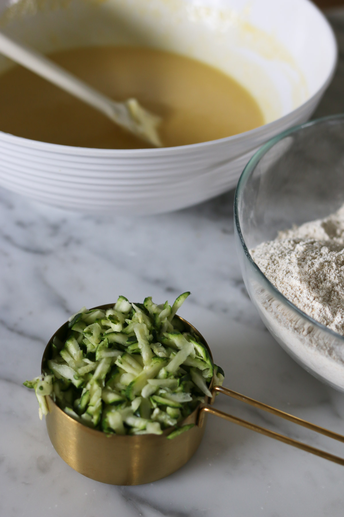 A measuring cup holds shredded zucchini