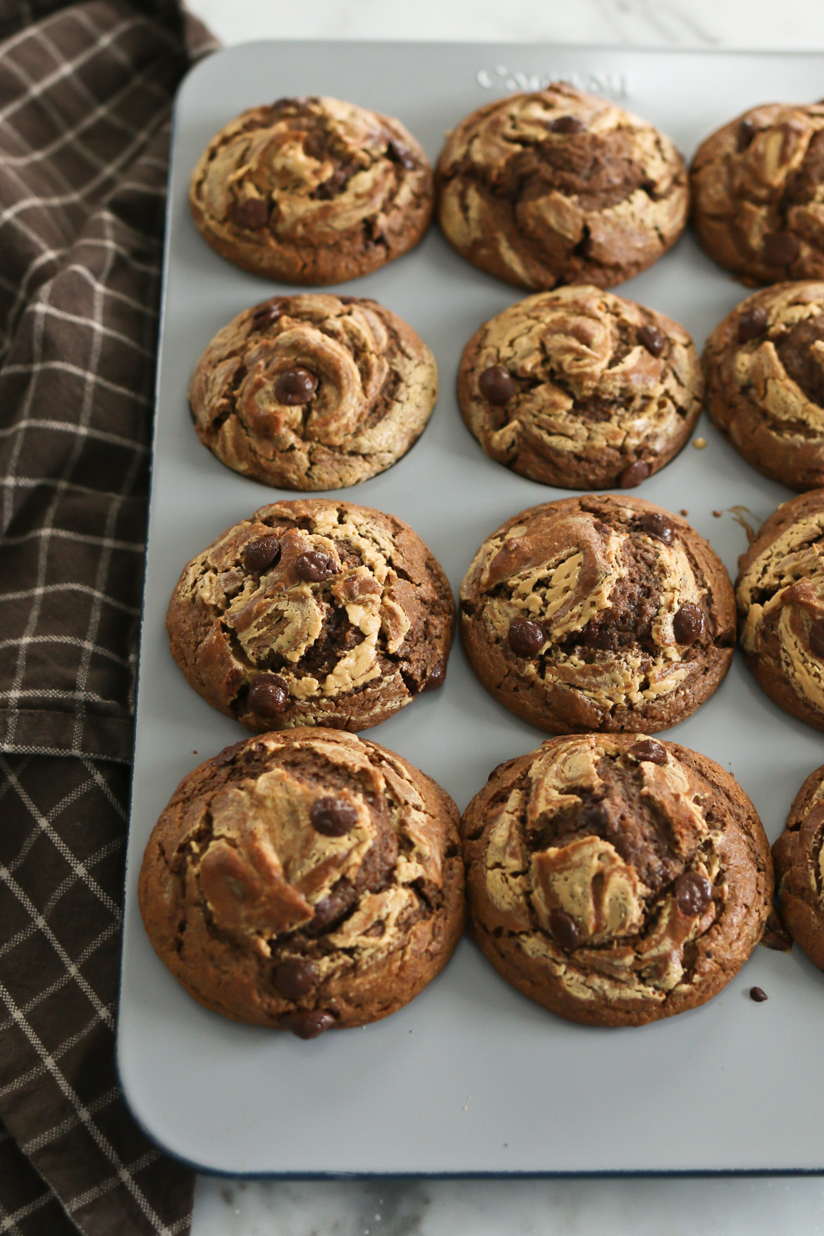A muffin tin holds baked chocolate and peanut butter muffins