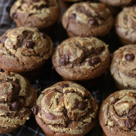 Several peanut butter chocolate muffins are arranged together after baking